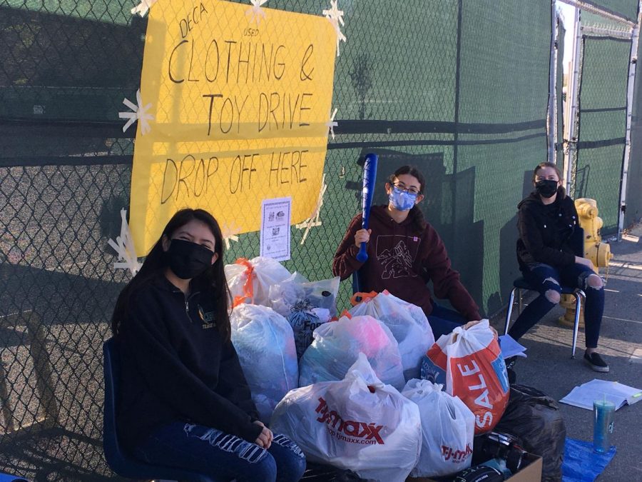 DECA club members Raquel Kanalz, Daisy Popick, and Ashtyn Parkinson collecting used clothing and toys for the needy at the west gate on December 4. Senior Daisy Popick said, "The drive was a huge success!"