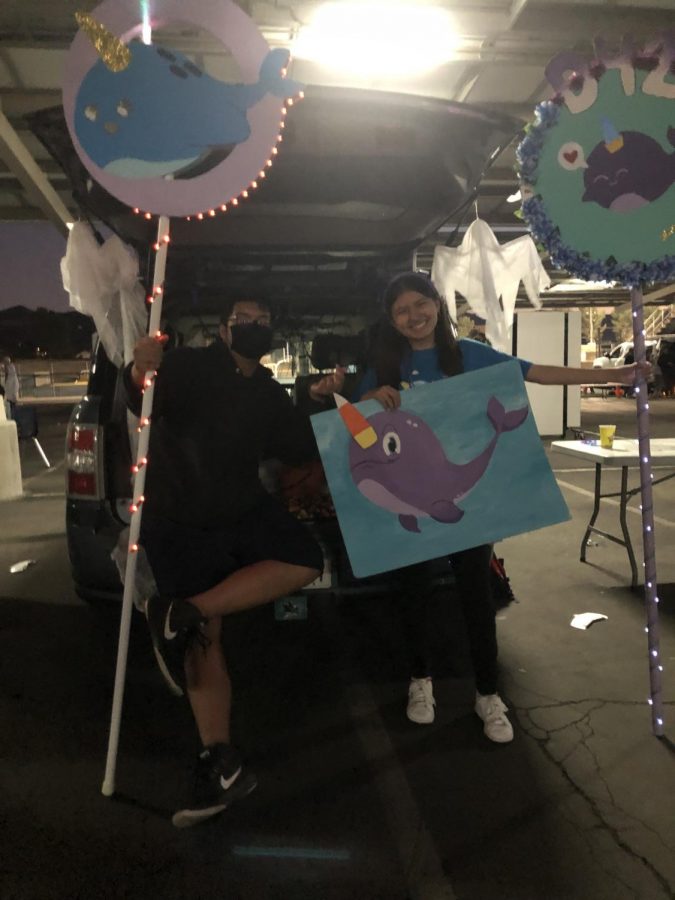 Junior Ze Situ and senior Raquel Kanalz handing out candy for Key Club at the Trunk or Treat event.