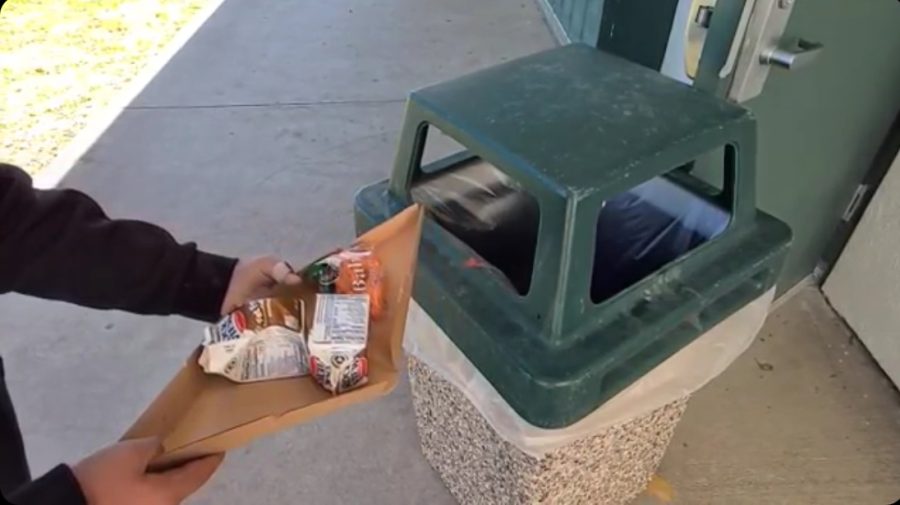 A student contributing to their responsibility of keeping the campus clean