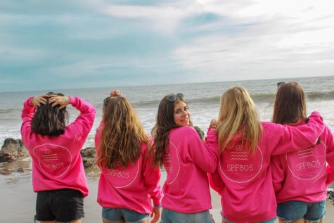 Senior Hope Gonzalez standing with juniors Sofia Berry, Bailey O’Connor, and Zoe Misiowiec to model SPF 805 hoodies near the beach.