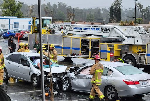 Firefighters attempt to remove the dead (Mikhal-King Thomas) and injured (Ana Saucedo) from the staged accident in the Senior Parking Lot. 
