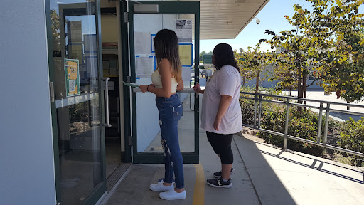 Seniors Cecilia Almada and Makayla Bell going to the Work Experience office, located at the back of the library, to renew their Work Permits.