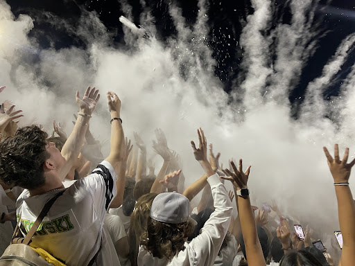 Students throw baby powder in the air to cheer on the football team during the third quarter.