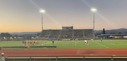 Girls Flag Football teams huddling up together, figuring out new strategies while pumping each other up during a timeout.