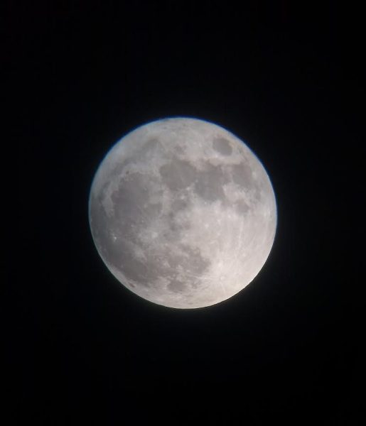 Looking through a reflector telescope, the moon shows its face.