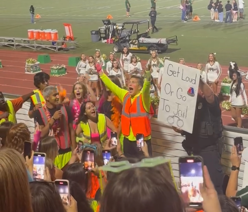 Student section leaders encouraging the crowd to cheer for Varsity football. 