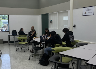 Students studying through peer tutoring inside the library.