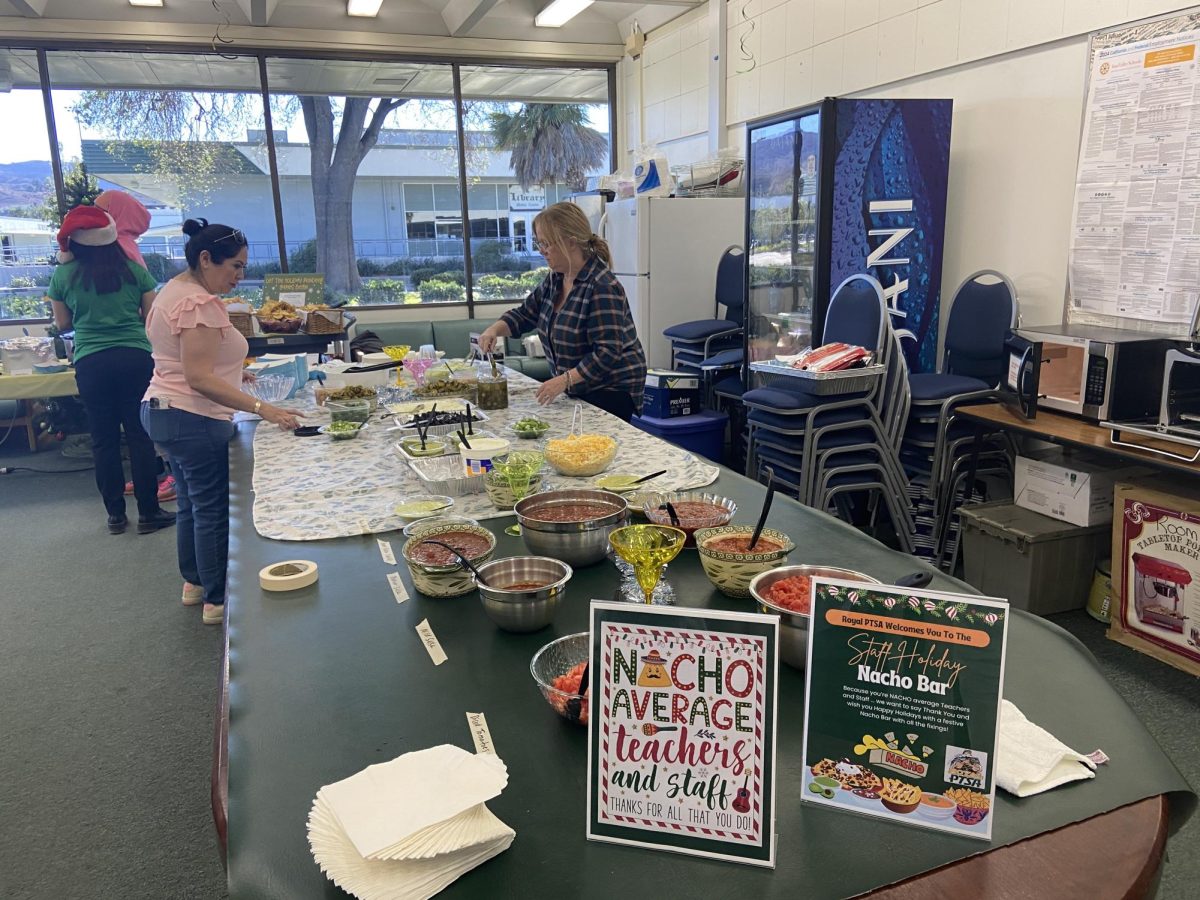 PTSA ladies setting up all the fixings and ingredients for the nacho bar in the staff lounge before finals are over for the day.