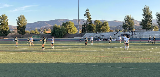 Our girls freshmen soccer team passing the ball to score.