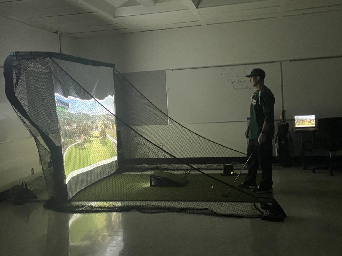 Girls Golf Coach, Richard Letus, about to hit on the golf simulator.