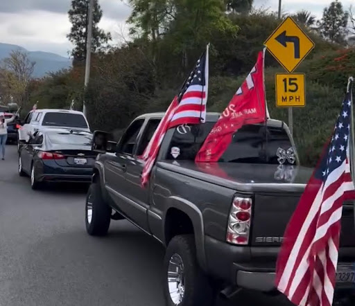 A flag-adorned truck parades through the city, showcasing support for President Trump's 2025 initiatives and celebrating his return to office.