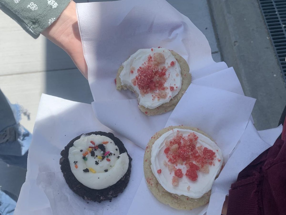 Seniors trying the flavor lineup of the week eating the birthday cake cookie and the strawberry ice cream bar cookie.