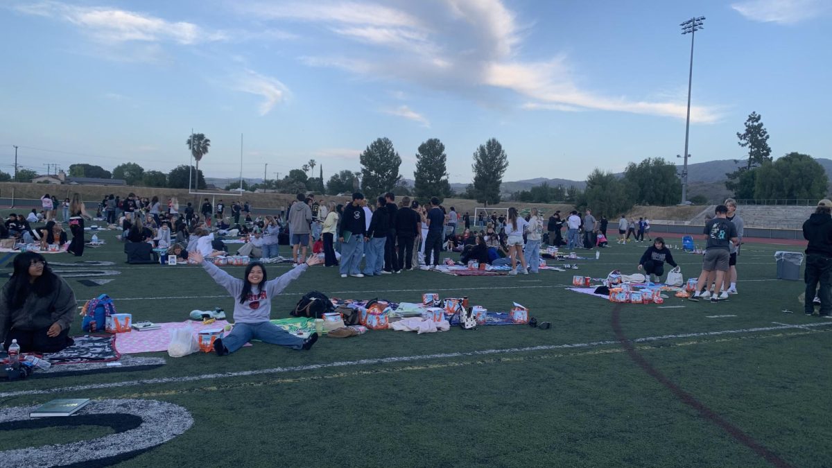 Seniors walking around the stadium field getting their yearbooks signed.