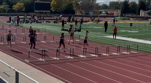 Runners clearing hurdles during the track meet.